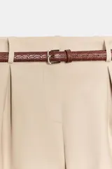 Bermuda negra de tiro alto con pinzas delanteras, bolsillos laterales y falsos bolsillos de vivo en la espalda. Incluye un cinturón delgado de cuero marrón con hebilla dorada.