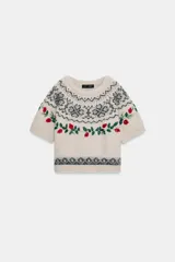 Jersey de punto de cuello redondo y manga corta, color beige con diseño de jacquard geométrico y bordados de flores y hojas en tonos rojos y verdes.
