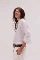 Blusa de lino color blanco, con silueta relajada de corte en A, cuello Mao, escote en V y mangas largas con puño de doble botón.