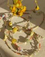 Collar corto de cuentas de colores con dije de pez de cerámica, piedras naturales y detalles en plata 925.