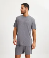 Conjunto de pijama para hombre, compuesto por una remera de manga corta y cuello redondo, y un short con cintura elástica y cordón de ajuste. El tejido es malla flamê con efecto mezcla en tonos de gris.