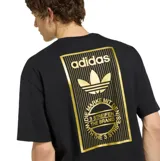 Remera Adidas de manga corta, color negro, con cuello redondo y diseño holgado. Presenta un parche rectangular dorado con el logo de la marca en el pecho.