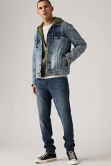 Pantalón de jean azul oscuro, corte slim fit, con pierna cónica y tiro medio. Diseño clásico de cinco bolsillos.