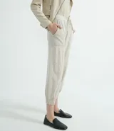 Pantalón estilo jogger de suedine, con cintura elástica y cordón ajustable, puños elásticos en los tobillos, bolsillos laterales y detalles perforados en los laterales y bolsillos.