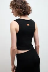 Chaleco negro de punto con escote en V y cierre frontal con dos ganchos metálicos.