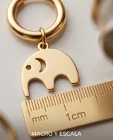 Caravanas de acero dorado tipo argolla con dije colgante en forma de elefante minimalista.