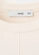 Chaleco de punto fino color beige, de diseño recto, cuello redondo y manga corta.