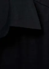 Camisa de lino negra, de manga larga con puños abotonados, cuello camisero y cierre frontal de botones.