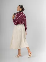 Falda midi de corte clásico confeccionada en corderoy, con cintura elastizada, diseño de tablas y bolsillos laterales. Incluye un cinturón desmontable en color marrón.