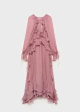 Vestido largo de gasa semitransparente en color rosado, con diseño de volantes verticales en el frente, escote en pico con cierre de lazo y mangas largas abullonadas. Incluye forro interior.