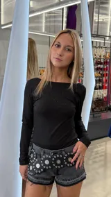 Body de manga larga en color negro con sutil acabado brillante. Presenta un escote redondo amplio y un diseño ajustado al cuerpo.