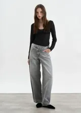 Jean de corte baggy con cintura cruzada y cierre asimétrico, confeccionado en denim de tono gris lavado.