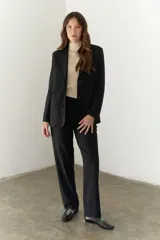 Blazer negro de poliéster, viscosa y spandex, con forro animal print, hombreras, botones frontales y en mangas.