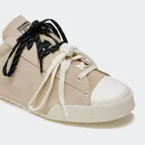 Championes Converse Chuck Lo Pro de gamuza color beige, con puntera de goma blanca, detalles de cuero en el talón y doble juego de cordones intercambiables en color blanco y negro jaspeado.