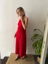 Conjunto de dos piezas color rojo. Incluye un top halter con argolla decorativa en el escote y lazo ajustable en el contorno. La falda es larga, recta y de diseño cruzado regulable.