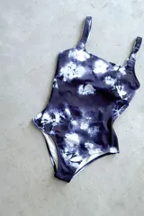 Traje de baño enterizo con estampado tie-dye en tonos azul y blanco, escote recto, tiras anchas y espalda cuadrada con almohadillas desmontables.
