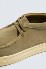 Zapato de cordones con parte superior de piel con acabado en serraje, detalle de bordón en el empeine, horma redonda y suela a contraste.