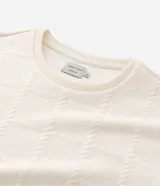 Buzo de cuello redondo y manga larga, confeccionado en tejido de poliéster con textura de efecto cuerdas en toda la prenda. Presenta puños y ruedo acanalados, con un corte regular que ofrece un ajuste cómodo y anatómico.