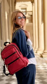 Mochila de tafeta color bordó, con compartimento principal con cierre, bolsillo frontal con doble cierre metálico y correas regulables.