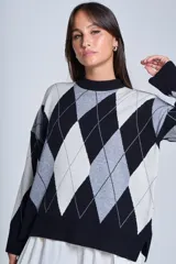 Sweater de punto con diseño de rombos en tonos beige y blanco, cuello redondo y corte holgado.