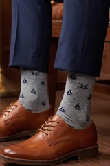 Media de algodón color gris con estampado de barcos y logo en azul marino.