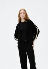 Campera negra de punto con capucha y cierre frontal.