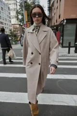 Abrigo largo de corte oversize con cuello de solapa, manga larga y cierre frontal cruzado con botones. Cuenta con bolsillos delanteros.