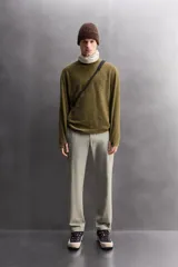 Sudadera de ajuste regular, color verde oliva, con cuello redondo y manga larga. Presenta una textura irregular en el tejido, similar al borreguito o bouclé.