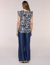 Blusa holgada de viscosa liviana con estampado animal print tipo leopardo, escote en V y mangas casquillo con volados en los hombros.