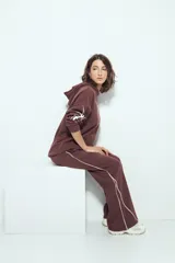 Pantalón babucha negro de silueta amplia y caída relajada, con detalle de líneas blancas laterales y cintura elastizada.