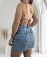 Top tejido al crochet color coral, con diseño asimétrico y tirante fino.