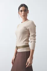 Sweater de tejido tipo rib, color negro, con cuello redondo y mangas largas. Presenta una textura acanalada y un ajuste al cuerpo.