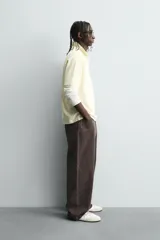 Pantalón de corte baggy fit confeccionado en tejido de algodón con textura y efecto lavado. Presenta diseño de cinco bolsillos, cierre frontal con cremallera y botón.