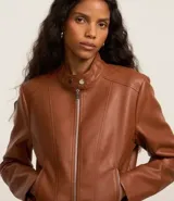 Campera de cuero sintético color marrón, con cuello alto abotonado, cierre frontal y bolsillos laterales con cremallera.