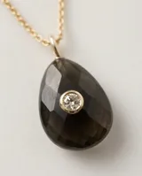 Collar de acero con baño de oro y cadena fina, con dije de piedra natural ónix en forma de gota y circonia central color verde oliva.