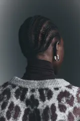 Buzo oversized de punto jacquard con estampado de leopardo, cuello redondo acanalado y hombros caídos. Presenta puños y bajo con terminación acanalada.