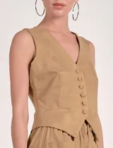 Chaleco color beige de estilo formal, con escote en V y cierre frontal de botones. Presenta bolsillos falsos a la altura de la cintura.