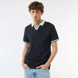 Remera de piqué de algodón color azul marino, con cuello polo en contraste color crema y detalles de rayas verdes y blancas en el cuello y los puños.
