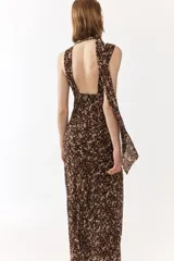 Vestido largo de gasa con estampado animal print en tonos marrones y beige, cuello halter con pañuelo incorporado, escote en V y diseño ajustado.