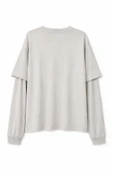 Remera de manga larga color bordó con efecto lavado, diseño de doble manga y estampado de estrellas en tono más claro.