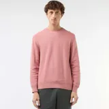 Sweater de punto con textura nido de abeja, color rosado, con cuello redondo y mangas largas.