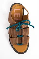 Sandalias de cuero color marrón, con suela track marrón oscura y cordones estilo marinero en color verde azulado que cruzan la capellada.