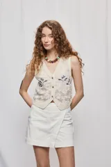 Falda short de tiro medio color blanco, con diseño cruzado en el frente que simula una falda, manteniendo la comodidad de un short. Presenta cintura definida y líneas simples.
