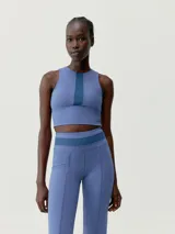 Top deportivo cropped negro, de sujeción media alta, con tejido Skin_Move ligero y resistente. Diseño elegante que combina tejido de alto rendimiento con malla transpirable. Banda ancha para sujeción y copas extraíbles.