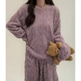 Conjunto de pijama de dos piezas confeccionado en plush suave con textura de ochos. Incluye una remera de manga larga con cuello redondo y un pantalón de corte recto con cintura elástica.