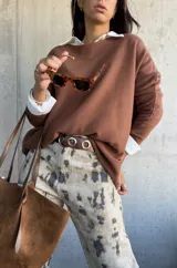 Sweater de punto color chocolate, de corte holgado y manga larga, con cuello redondo.