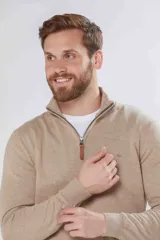 Buzo de tejido fino en hilo de algodón, color rosado, con cuello alto y cierre frontal parcial con detalle en cuero. Presenta puños y ruedo acanalados y un pequeño logo bordado en el pecho.