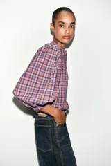 Blusa de cuello redondo y manga larga abullonada, con estampado de cuadros en tonos rosados, violetas y blancos. Cierre frontal con botones.