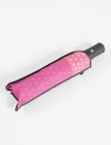 Paraguas plegable automático con estampado de lunares rosas y blancos.