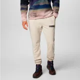 Pantalón de jogging Columbia modelo Beaumount, de color beige con puños elásticos en los tobillos y bolsillos laterales. Cuenta con el logo de la marca bordado en la pierna izquierda.